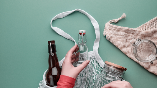 string bag with glass bottles and jars on green backdrop