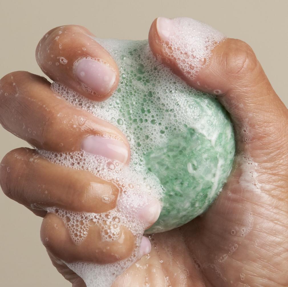 hand holding foaming zero waste shampoo bar