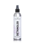 A tall 9 fluid oz mist bottle of a simple planets plant based and biodegradable detangler spray. It has a black lid and a white and purple label.