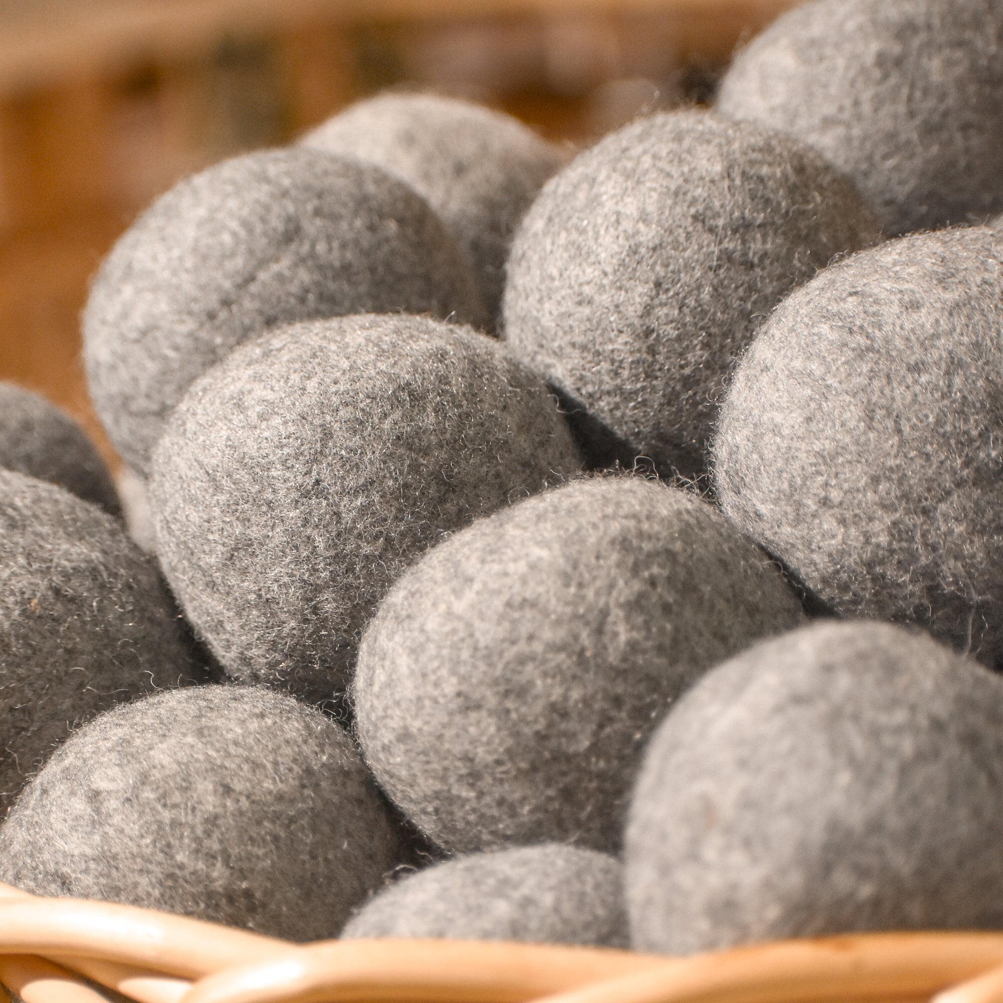 A close-up of Bamboo Switch Dryer Balls, made from natural wool, piled in a woven basket—ideal for reducing dry time and minimizing wrinkles in your laundry.