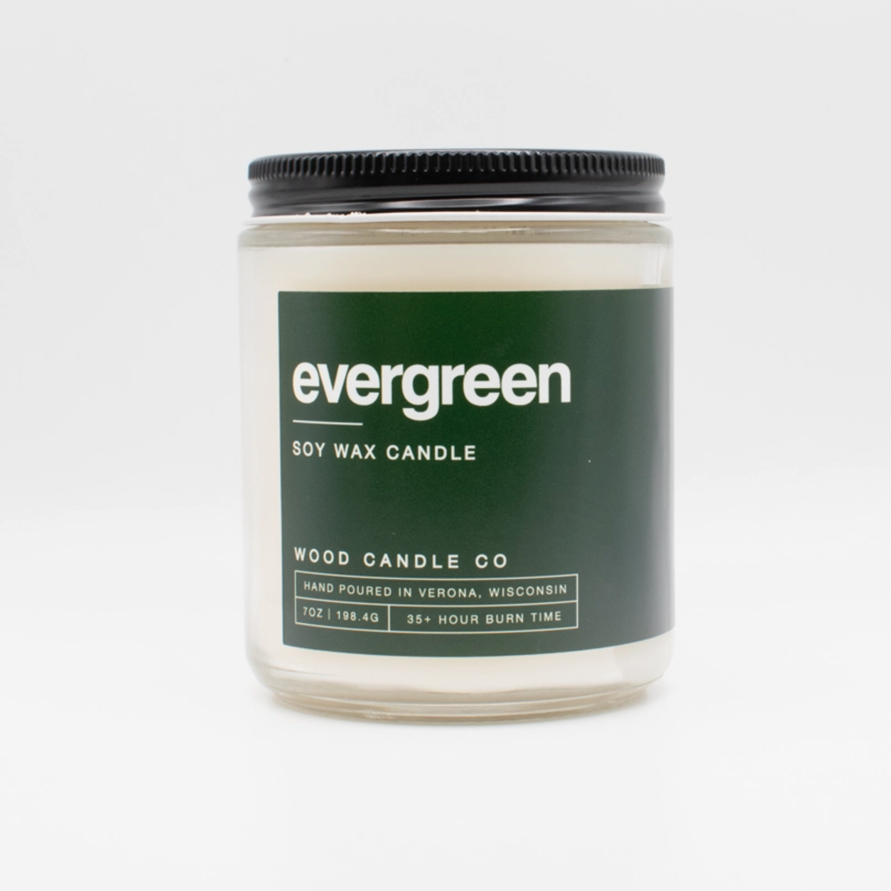 Wood Candle Co. Soy Candle—7oz glass jar with black lid and dark green evergreen label. Hand-poured in Wisconsin, delivers a long-lasting fragrance and 35+ hours of burn time.