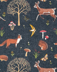 dark grey fabric with trees, mushrooms, butterflies, foxes, flowers and deer.