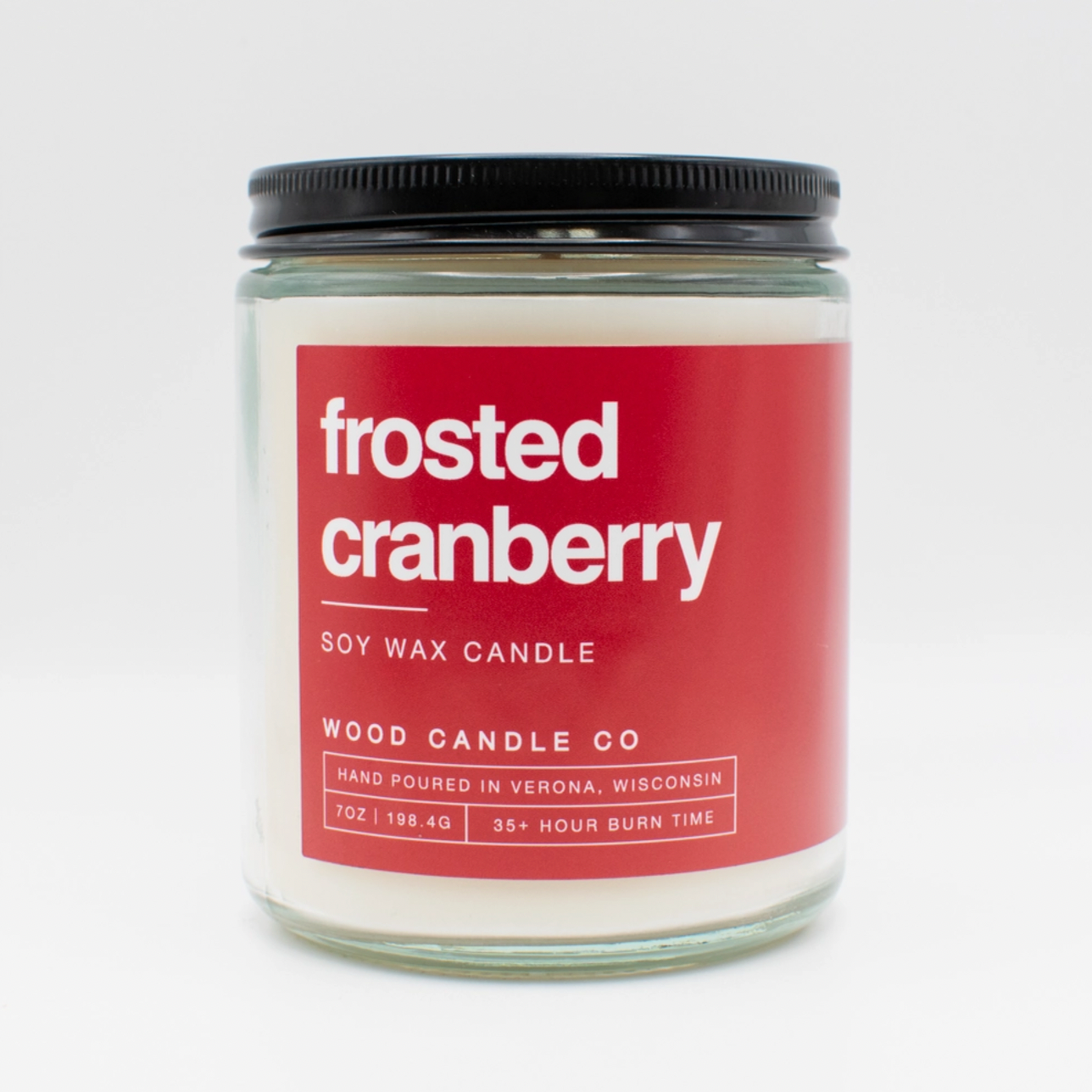 The Wood Candle Co. Soy Candle is a 7 oz hand-poured soy wax candle in a glass jar with black lid, featuring the Frosted Cranberry scent, made in Verona, Wisconsin. Enjoy over 35 hours of long-lasting fragrance.