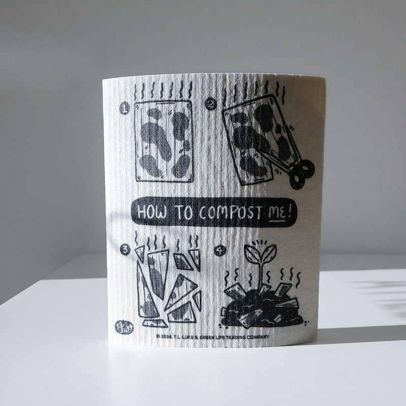 The Potluck Press Swedish Dishcloth in white features composting instructions—cut the absorbent cloth, place it in your compost bin, and let it decompose. How to compost me! is printed above the illustrated steps.