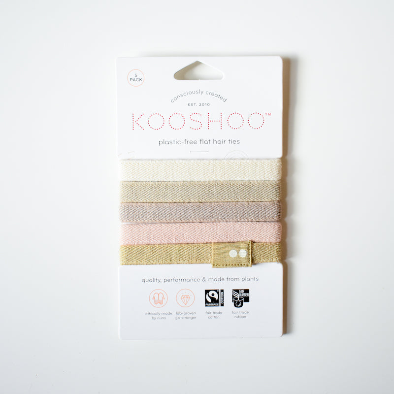 A pack of KooShoo Biodegradable Hair Ties in neutral and pastel shades, shown on white packaging that emphasizes their eco-friendly, plant-based, and plastic-free materials.