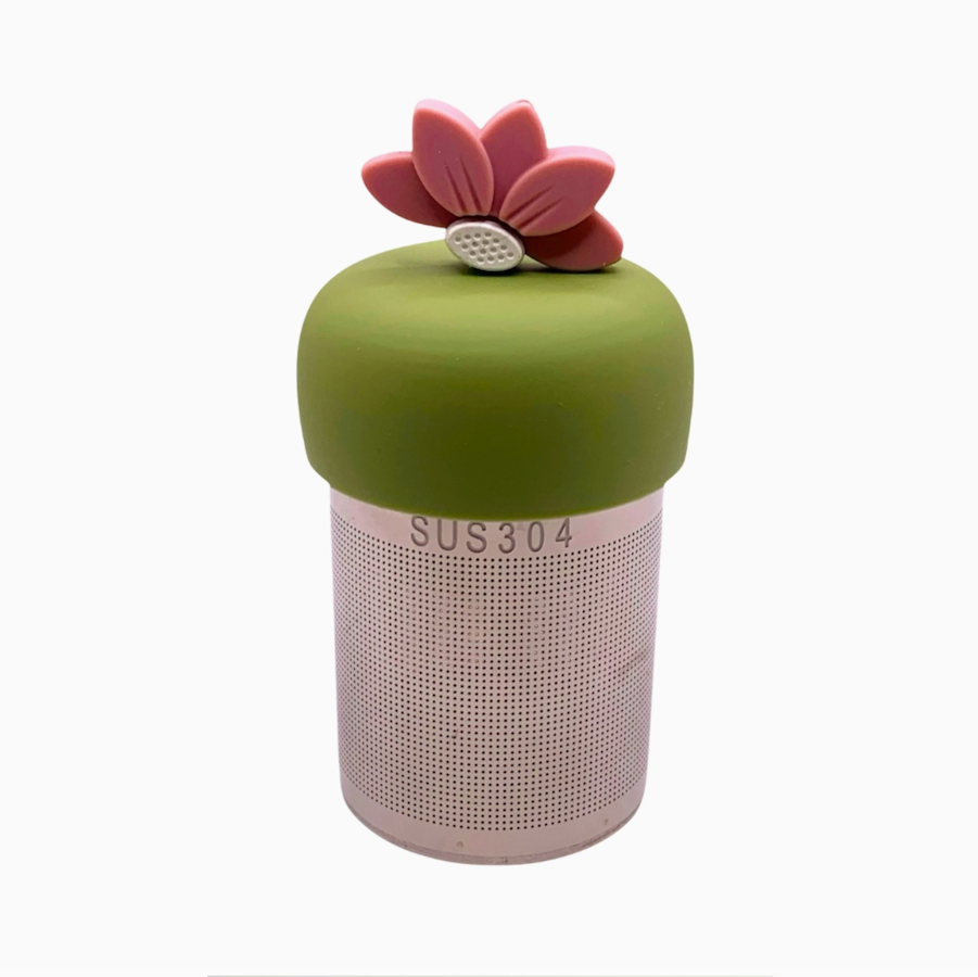 The Teany Tiny Kitchen Floating Tea Infuser features a stainless steel SUS304 perforated body and a green silicone lid adorned with a pink lotus for an innovative tea steeping experience.