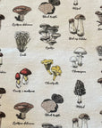 No paper towel with botanical illustrations of a variety of mushrooms on a cream background.