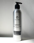 metal bottle of lotion on white backdrop