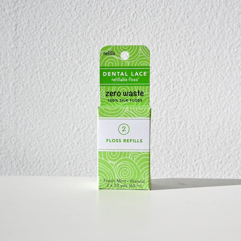 A box of Dental Lace Compostable Floss refills, with green and white packaging for fresh mint-waxed silk floss, includes two 100% compostable refills for your container, shown upright against a white background.