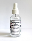 Bottle of eyeglass lens cleaner with a white label on a light gray background