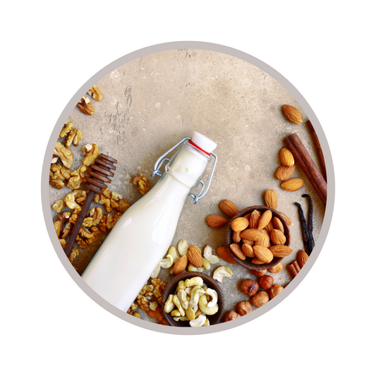 bottle of milk surrounded by almonds and various nuts 