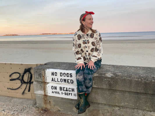 Emily Popp, Designer, Sitting on retaining wall with the ocean beyond