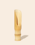 The bamboo scoop standing up on a white background. 