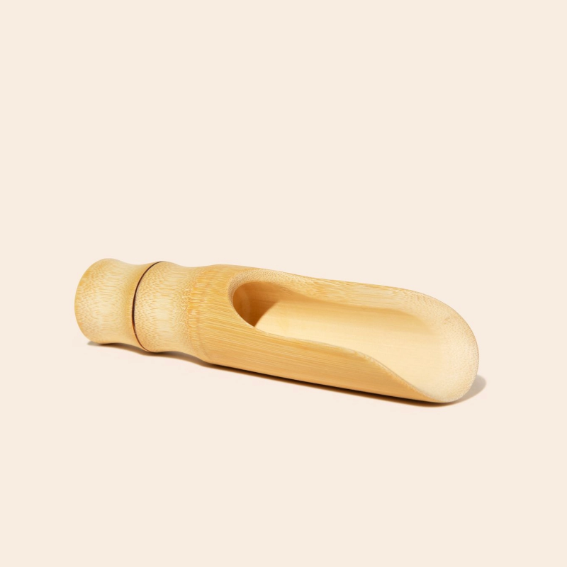The bamboo scoop lying on a white background. 