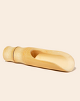 The bamboo scoop lying on a white background. 