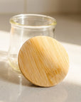 A small Oui yogurt jar with a bamboo lid resting on it, ready to be reused!