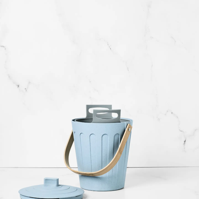 The light blue small compost bin with a compost bin liner in it. 