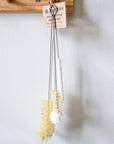 Bottle cleaning brush set with a wooden hook on a white wall