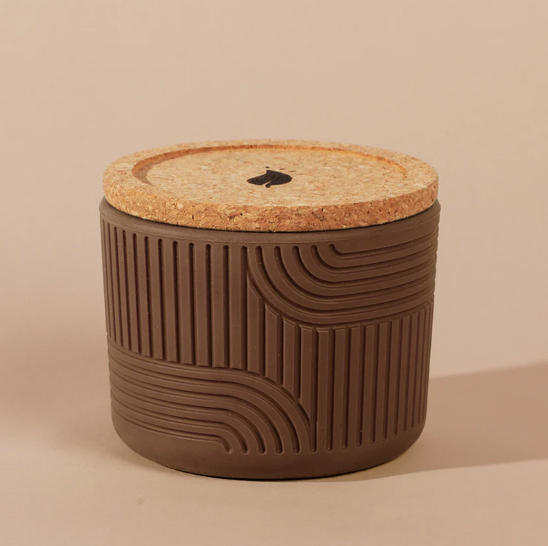 Brown textured container with a cork lid on a beige background