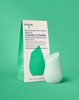 Solid conditioner bar and packaging on a green background