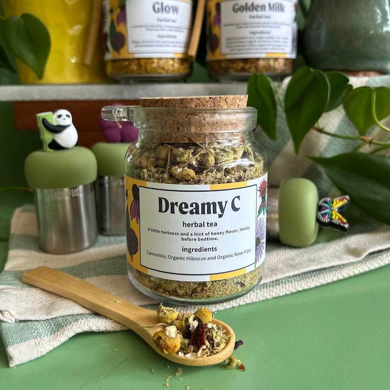 A refillable jar of dreamy c tea. The jar has a cork lid and an attachable bamboo spoon. 