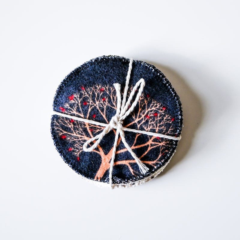 Round woven item with tree design and twine on a white background