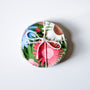 Round, colorful fabric product with a floral pattern on a white background