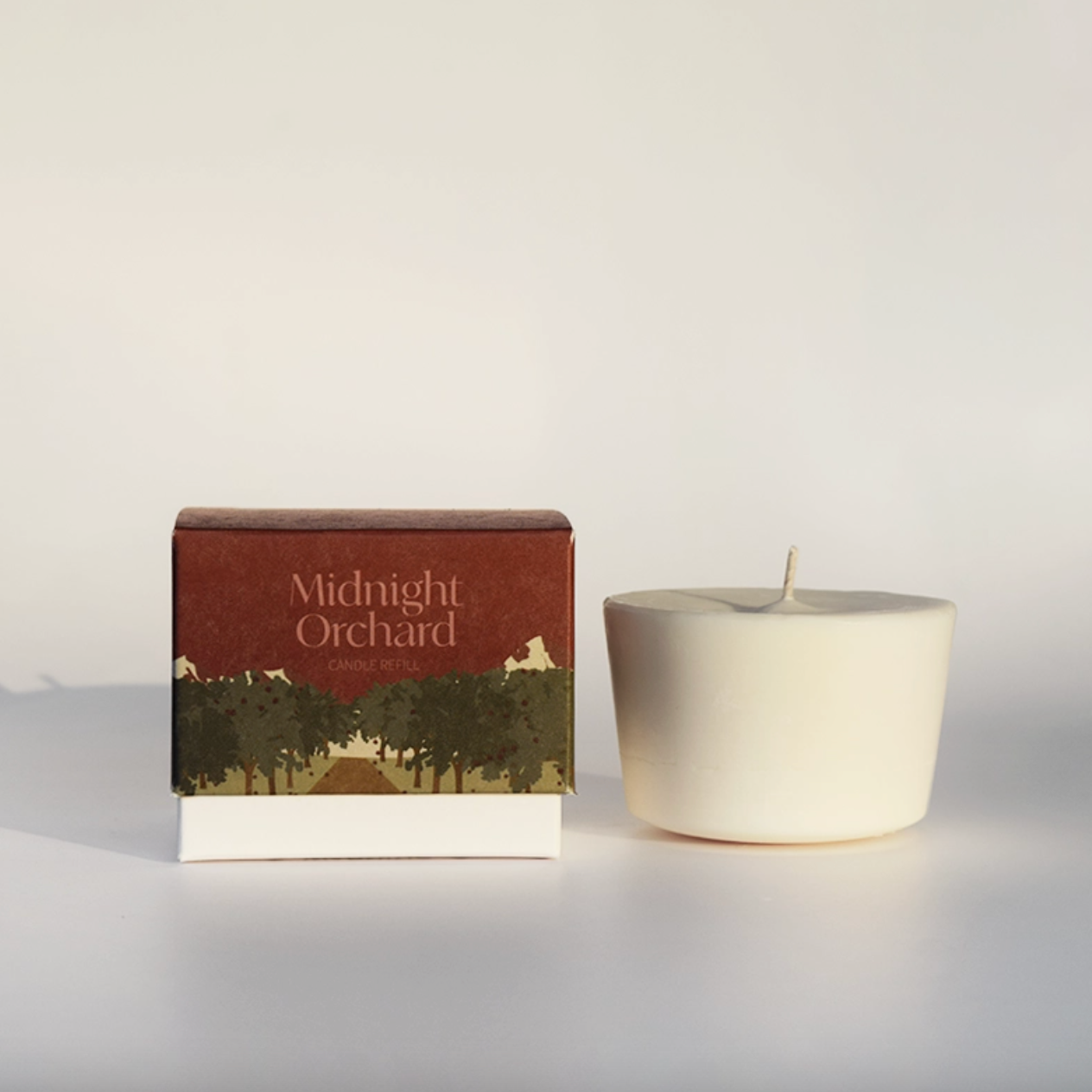 Midnight Orchard Candle refill next to box on white backdrop