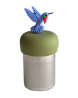A Stainless steel and silicone floating tea infuser. The top silicone part is green with a blue red and green hummingbird  charm on top of it.