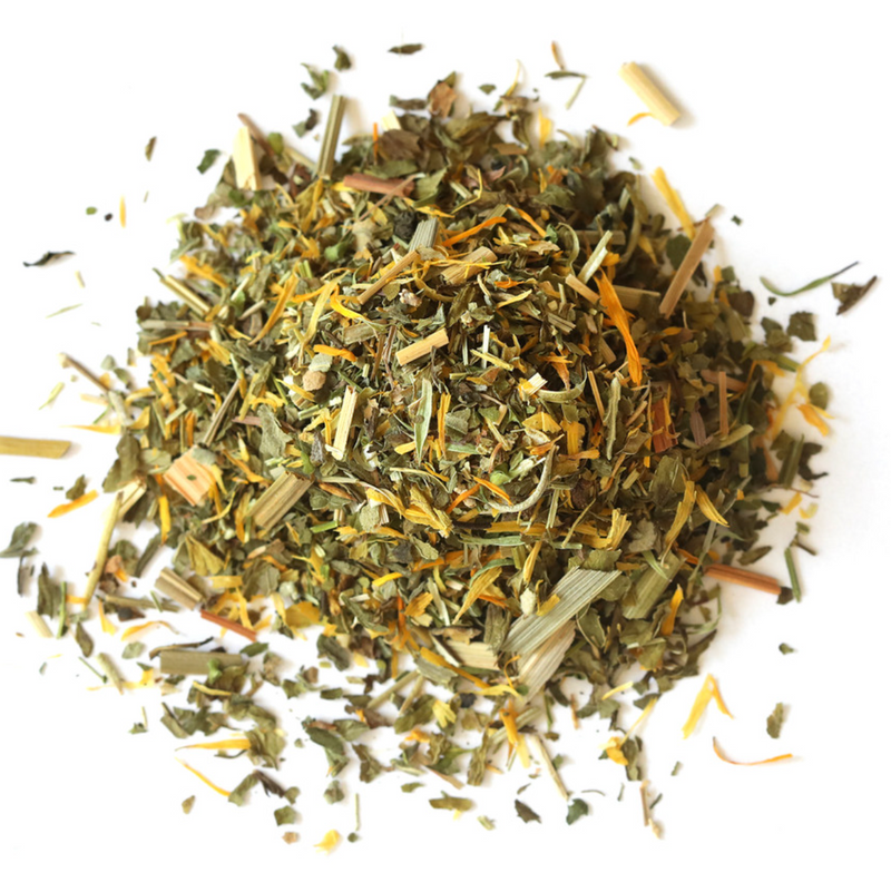 Loose, dried Happy Tummy Tea by Mountain Rose Herbs, featuring green and yellow herbal leaves and flower petals, arranged on a white background.