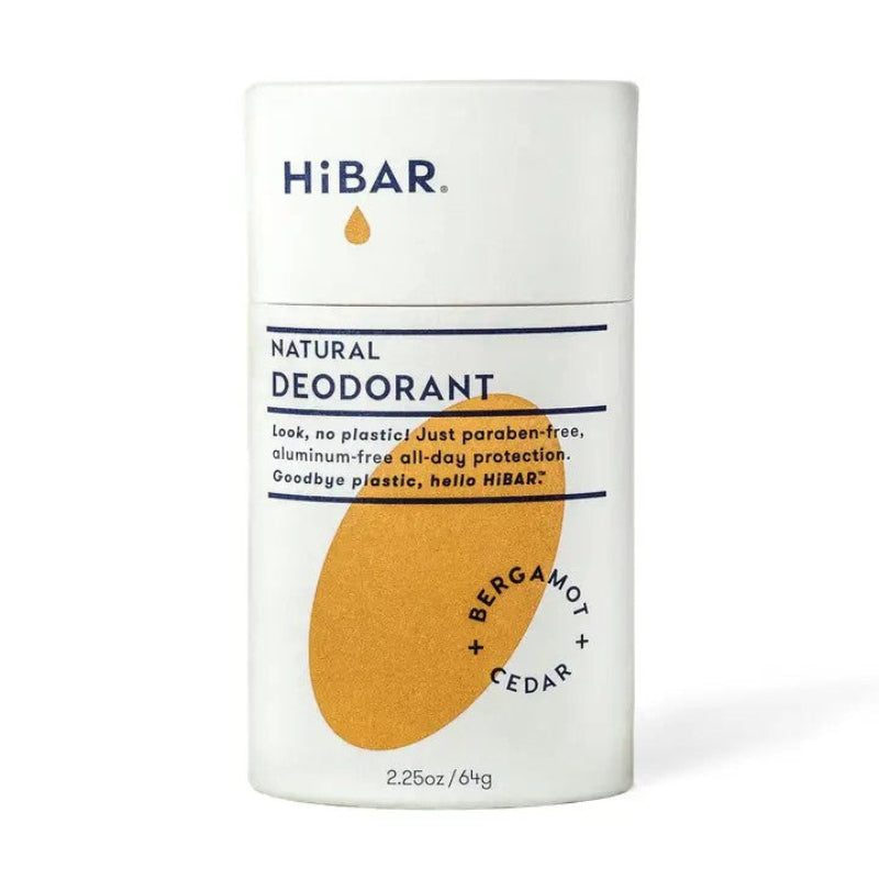 A white paper deodorant tube with a orange oval hibar branding on it in the Bergamot and cedar scent. 