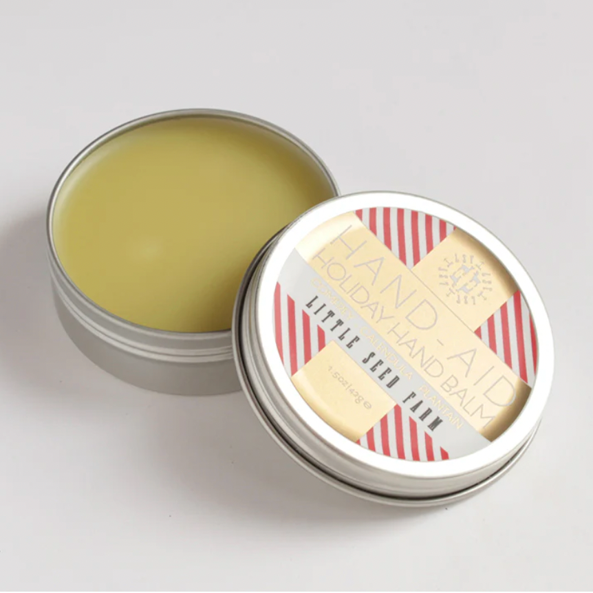 Tin of hand balm on white backdrop