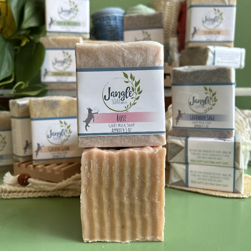 Jangle Soaps Rose Goat's Milk Soap wrapped in white paper and on top of a bulk loaf of the same soap.