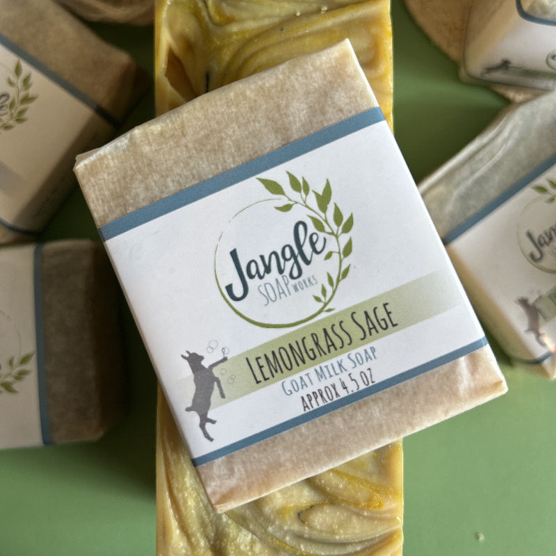Jangle Soaps Lemongrass Sage Goat's Milk Soap wrapped in white paper and on top of a bulk loaf of the same soap.