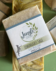 Jangle Soaps Lemongrass Sage Goat's Milk Soap wrapped in white paper and on top of a bulk loaf of the same soap.