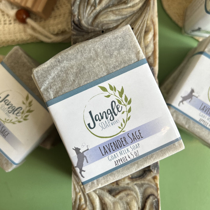 Jangle Soaps Lavender Sage Goat's Milk Soap wrapped in white paper and on top of a bulk loaf of the same soap.