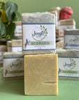 Jangle Soaps Trees of Wisconsin Goat's Milk Soap wrapped in white paper and on top of a bulk loaf of the same soap.