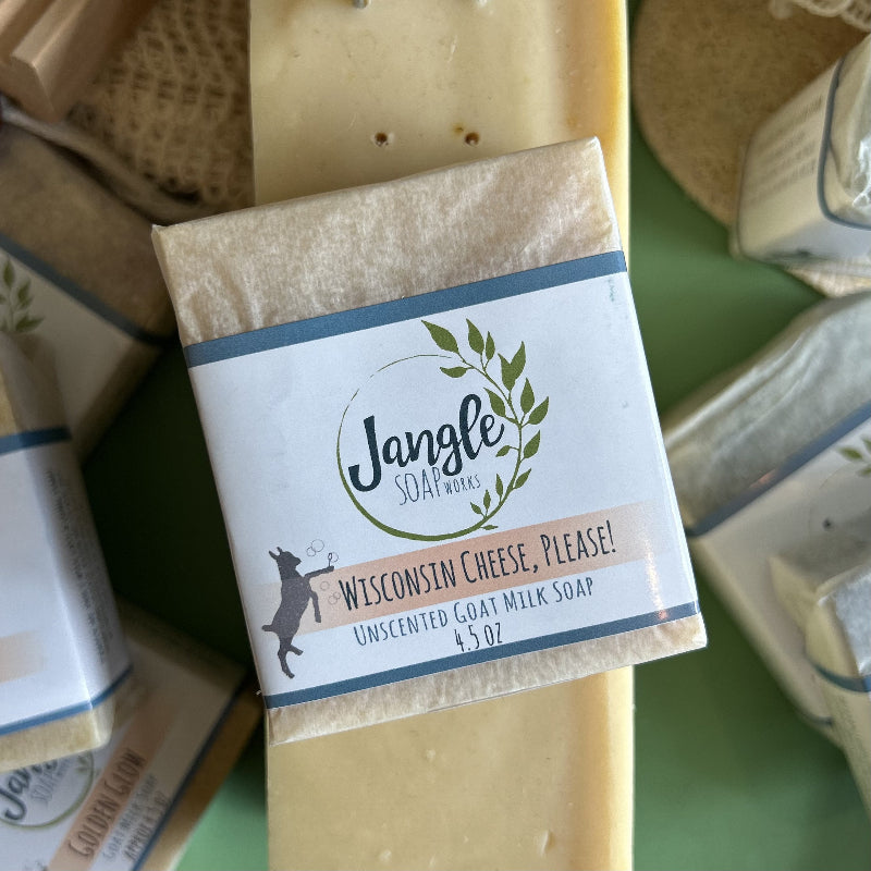 Jangle Soaps Wisconsin Cheese Please! Goat's Milk Soap wrapped in white paper and on top of a bulk loaf of the same soap.