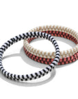 Three handmade biodegradable hair ties on a white background. All the hair ties have a chevron pattern, One hair ties is Black and white, one is beige and white and one is pink and brown. 