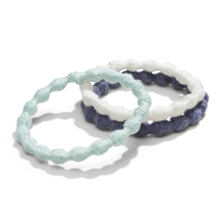 Three handmade biodegradable hair ties on a white background. All the hair ties have a pearled pattern alternating from being rounded to flat, One hair tie is white, light blue,  and one is navy. 
