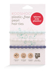 Pack of biodegradable handmade hair ties designed to fit comfortably around your wrist.  Three pearl hair ties wrap around the packaging. One hair tie is white, one is baby blue,  and one is a denim blue. 