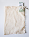 Mesh tea bag with a green tea package on a light gray background