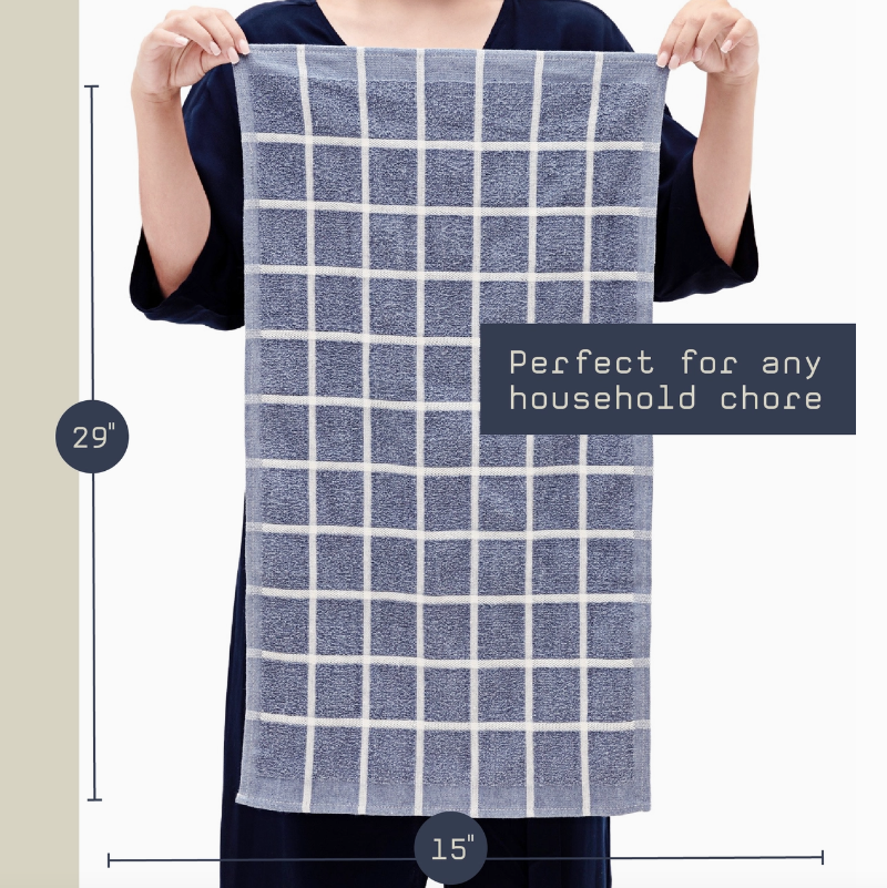 Person holding a blue and white checkered towel with dimensions and text on a plain background