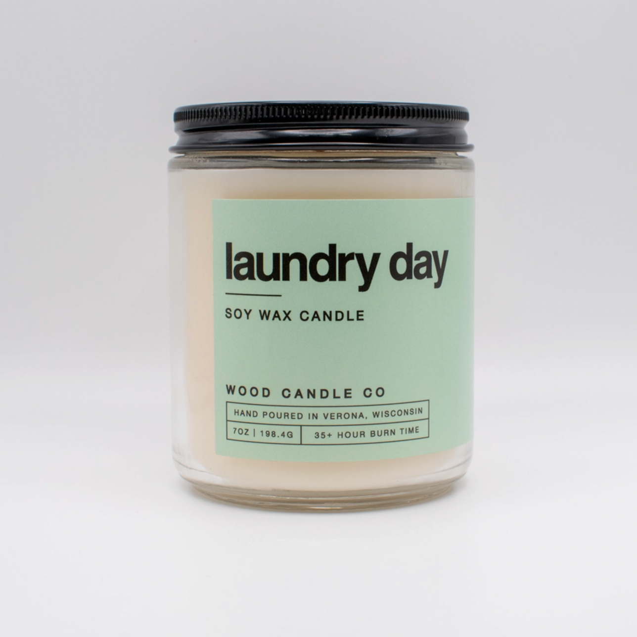 Candle Jar with light green label; "laundry day" on white background 