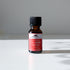 A 0.5 fl oz (15 mL) amber bottle of Mountain Rose Herbs Lavender Essential Oil rests on a white surface in bright light, casting a shadow. This certified organic oil offers a floral aroma ideal for aromatherapy.