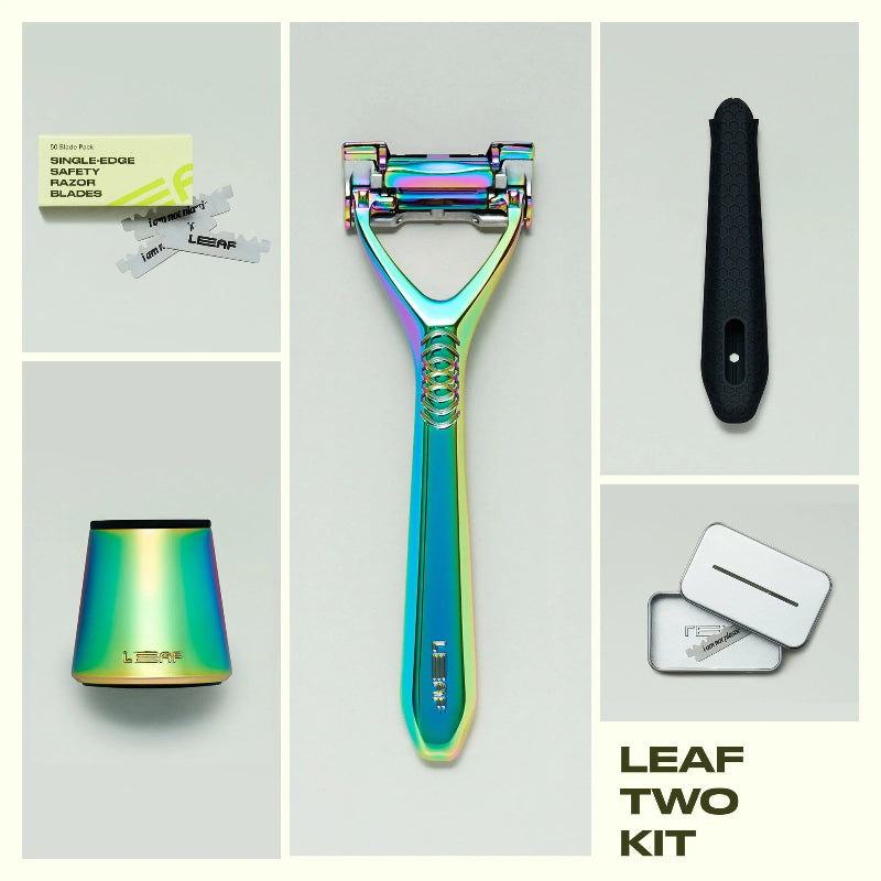 A flat lay of the leaf two razor kit in the color prism.  The image shows the contents of the Leaf two razor kit next to the razor is a 50 count refill pack, a matching prism stand, a silicone handle sleeve, and a recycling tin.