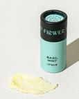 A tube of basil mint lip balm in an eco friendly paper tube that is blue and black. 