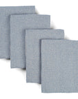 Four light blue waffle weave upcycled cotton towels lying on top of each other on a white background. 