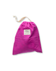 A Magenta Bee's wax lined bread bag with a drawstring top pulled shut on a white background.