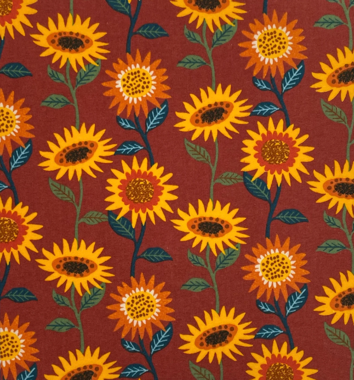 No paper towel with yellow and orange sunflowers on a maroon background.